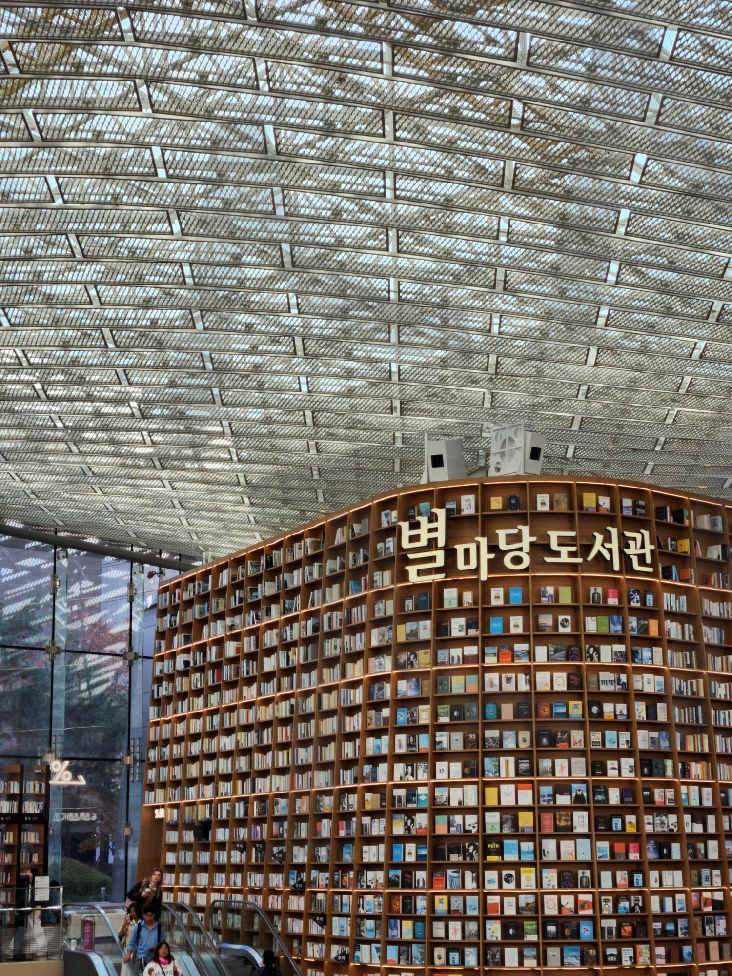 별마당 도서관의 책의 숲: 서울 코엑스의 랜드마크 | 별마당도서관, 코엑스, 서울, 도서관, 책, 서가, 유리천장, 랜드마크, 문화공간, 현대건축, 복합문화, 여행지, 독서, 도시풍경, 인테리어, 에스컬레이터, 방문객, 지식, 감성사진, 한국 | 스탠바이 STANDBUY 디지털 콘텐츠